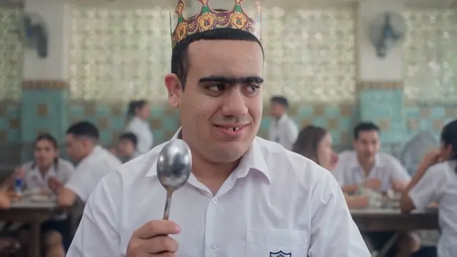Pachi with a paper crown and a spoon in the school canteen